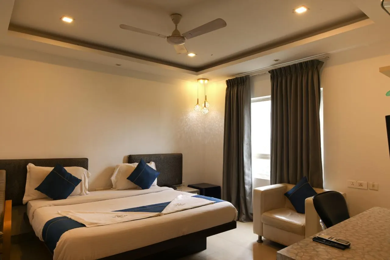 Deluxe Room with king bed, armchair and work desk